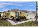 Attractive yellow home with neatly landscaped garden beds and a well-manicured lawn at 217 Holborn Loop, Davenport, FL 33897