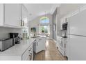 Well-lit kitchen with stainless appliances, white cabinets, stone countertops, and breakfast nook is perfect for families at 217 Holborn Loop, Davenport, FL 33897