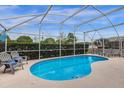 Inviting pool with screened enclosure and comfortable lounge chairs at 217 Holborn Loop, Davenport, FL 33897