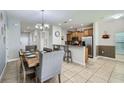 Bright, open-concept living space featuring tile flooring, a spacious dining area, and a breakfast bar at 3055 Beach Palm Ave, Kissimmee, FL 34747