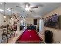 Spacious game room featuring a red felt billiard table, bar-height seating, and modern lighting fixtures at 3188 Verbena Ct, Deltona, FL 32725