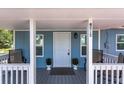 Inviting covered porch with a seating area, number display, and a neutral-colored entrance door at 4515 Isaac Ln, Sanford, FL 32771