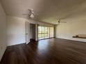 Well-lit living room features hardwood floors, a ceiling fan, and sliding doors leading to the balcony at 592 Orange Dr # 142, Altamonte Springs, FL 32701
