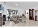 Inviting living room with tiled floors, neutral-toned furniture, and abundant natural light at 606 Marion Oaks Blvd, Ocala, FL 34473