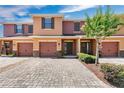 Charming townhome featuring a brick driveway, a one car garage, and inviting curb appeal with landscaping at 617 Joyful Blossom Pl, Longwood, FL 32750