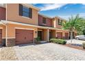 Charming townhome featuring a brick driveway, a one car garage, and inviting curb appeal with landscaping at 617 Joyful Blossom Pl, Longwood, FL 32750