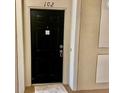A welcoming black front door with modern hardware and a plush door mat at 6451 Old Park Ln # 102, Orlando, FL 32835