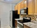 Well-equipped kitchen features granite countertops, stainless steel appliances, and wooden cabinetry at 6451 Old Park Ln # 102, Orlando, FL 32835
