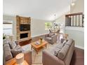 Bright living room with brick fireplace, neutral-toned sofas and hardwood floors at 721 Rock Creek Loop, Longwood, FL 32750