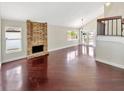 Bright living room featuring a brick fireplace, hardwood floors, and an open layout at 721 Rock Creek Loop, Longwood, FL 32750