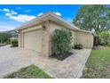 Side view of a home showing the garage, brick accents, and a paver walkway at 7549 Lake Marsha Dr, Orlando, FL 32819