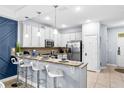 Stylish kitchen with a breakfast bar, white cabinetry, and stainless steel appliances at 8187 Roseville Rd, Davenport, FL 33896