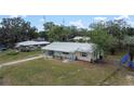 Wide aerial shot showcasing the charming single-story home, metal roof, and surrounding landscape at 88 E Charlotte Ave, Eustis, FL 32726