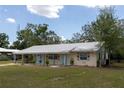Charming single-story home featuring a metal roof, pale yellow exterior and a well-maintained lawn at 88 E Charlotte Ave, Eustis, FL 32726