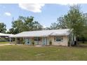 Charming single-story home with a covered porch, metal roof, and inviting curb appeal at 88 E Charlotte Ave, Eustis, FL 32726