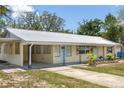Attractive single-story home boasting a metal roof, covered entrance, and well-maintained landscaping at 88 E Charlotte Ave, Eustis, FL 32726