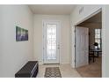 Bright foyer with decorative glass front door, tile flooring, and adjacent open room at 8933 Hinsdale Heights Dr, Polk City, FL 33868