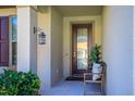 Inviting front porch with decorative door, lantern, and comfortable seating, creating a warm welcome at 8933 Hinsdale Heights Dr, Polk City, FL 33868