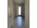 Inviting hallway with decorative front door and neutral tile flooring at 8933 Hinsdale Heights Dr, Polk City, FL 33868