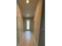 Bright hallway with decorative glass front door and neutral tile flooring at 8933 Hinsdale Heights Dr, Polk City, FL 33868