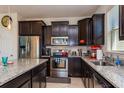Well-equipped kitchen with stainless steel appliances, granite countertops, and dark wood cabinetry at 8933 Hinsdale Heights Dr, Polk City, FL 33868