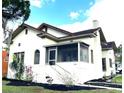 Charming home with a stucco exterior, terra cotta roof, a screened porch, and landscaped front yard at 900 Carlton Ave, Lake Wales, FL 33853
