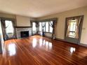 Spacious living room featuring gleaming hardwood floors, a brick fireplace, and abundant natural light at 900 Carlton Ave, Lake Wales, FL 33853