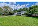 Landscaped front yard with green lawn leading to a charming single story home, complete with a one-car garage at 915 Oregon St, Orlando, FL 32803