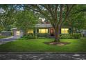 Charming single-story home featuring a well-maintained lawn and a mature shade tree with dark exposure at 927 Boardman St, Orlando, FL 32804