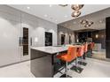 Modern kitchen showcasing glossy white cabinetry, stainless steel appliances, and stylish bar seating at 100 S Eola Dr # 1406, Orlando, FL 32801