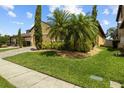 Landscaped front yard featuring lush green grass and mature trees adding shade and character to the home at 10111 Tierra Bella Dr, Orlando, FL 32825