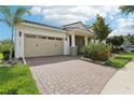 Charming home featuring a two-car garage, brick driveway, lush landscaping, and a well-maintained lawn at 10203 Henbury St, Orlando, FL 32832