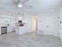 Bright, open-concept living space with new gray tile flooring and modern ceiling fan at 1113 Leeward Dr, Deltona, FL 32738