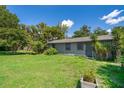 A charming single-story home with green grass, tropical landscaping and a partially fenced yard at 1121 Votaw Rd, Apopka, FL 32703