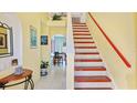 Inviting foyer with staircase, arched doorway, yellow walls, and tile flooring at 11257 Dacre Ln, Orlando, FL 32824