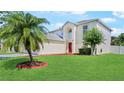 Charming two-story home features a well-manicured lawn, landscaping, and a bright red front door at 11257 Dacre Ln, Orlando, FL 32824