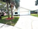 Inviting home with manicured lawn, palm trees, and attached two-car garage at 11373 Darlington Dr, Orlando, FL 32837
