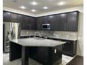 Modern kitchen featuring a large island, stainless steel appliances, and sleek cabinetry at 11464 Center Lake Dr, Windermere, FL 34786