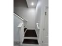 Clean staircase with white railing and dark wood steps, leading to upper level at 11464 Center Lake Dr, Windermere, FL 34786