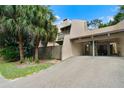 Beige two-story condo with car port and second story balcony, palm trees and green grass at 115 Tomoka Trl # 115, Longwood, FL 32779