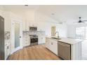 This updated kitchen features white cabinets, stainless steel appliances, and island with sink at 117 Sanderling Dr, Haines City, FL 33844