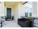 Inviting front porch featuring a dark blue front door, potted plants, and comfortable seating at 12133 Bracco St, Winter Garden, FL 34787