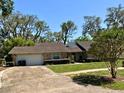 Charming single-story home with a well-maintained lawn, mature trees, and a two-car garage providing ample parking at 1219 Serissa Ct, Orlando, FL 32818