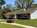 An inviting home, featuring brick accents, mature landscaping, and a well maintained lawn at 1219 Serissa Ct, Orlando, FL 32818