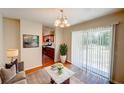 Bright living room features wood floors, chandelier, and sliding glass doors to the backyard at 14 Cyclops Dr, Apopka, FL 32703