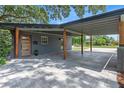 View of the carport with gray pavers, wooden posts, and dark gray painted support beams at 1401 Canberra Ave, Orlando, FL 32806