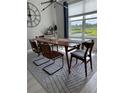 Modern dining room with large window, stylish chairs and minimalist decor at 15708 Orange Harvest Loop, Winter Garden, FL 34787
