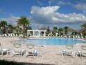 Community pool featuring comfortable lounge chairs for residents to relax and enjoy the sunny weather at 15708 Orange Harvest Loop, Winter Garden, FL 34787