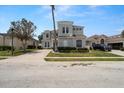 Well-manicured two-story home with lush landscaping and spacious driveway at 166 Minniehaha Cir, Haines City, FL 33844