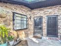 Close-up of the brick exterior with dual front doors, complemented by charming potted plants and a window at 1803 Foxhall Cir # 1803, Kissimmee, FL 34741